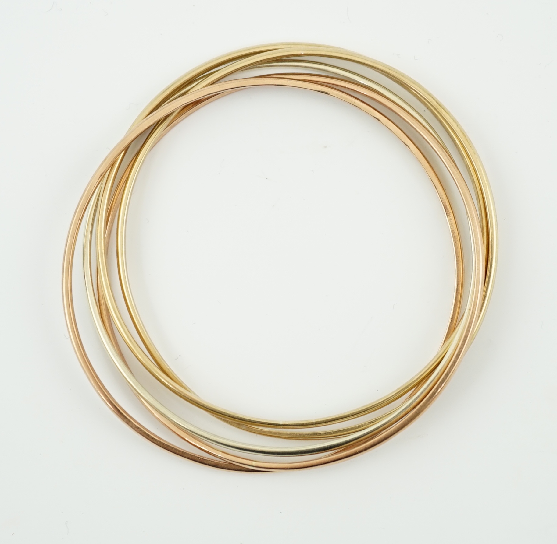 A set of five modern three colour 9ct gold inter-looping bangles